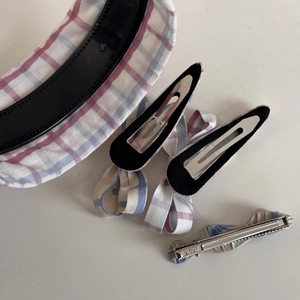 Détail de l'ensemble d'accessoires à carreaux avec bordure en dentelle et pinces à cheveux noeud