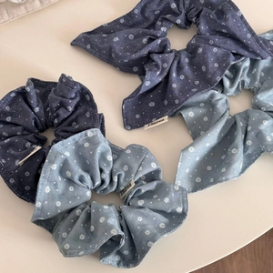 Detail view of denim blue floral scrunchies with bunny ear ties and soft cotton texture