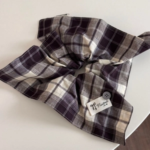 Detail of plaid scrunchie with grey button and Handmade woven label on white background