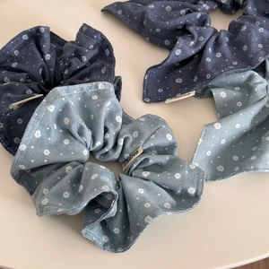 Detail view of floral denim fabric scrunchies in navy and light blue colors