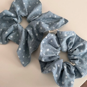 Blue floral denim fabric scrunchie set with white flower patterns and brand label