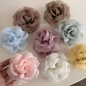 Detail of multi-colored layered chiffon rose hair claws in elegant Morandi color tones