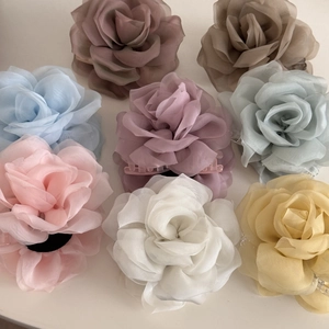Detailed macro view of tiered chiffon rose hair claws in multiple soft Morandi colors