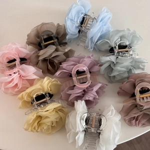 Detailed flat lay of eight multicolored chiffon rose hair claws on a clean white background