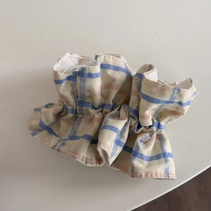Gros plan détaillé d'un chouchou à carreaux bleu et jaune avec dentelle et texture coton