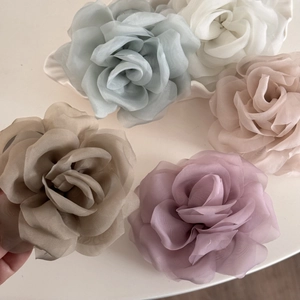 Detail of multi-colored chiffon rose hair claws in soft Morandi colors and layered fabric