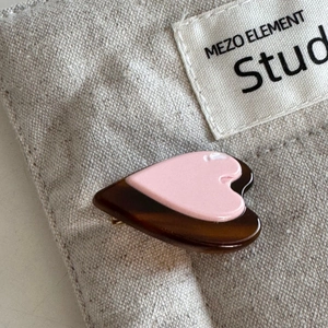 Detail of a double-layered heart-shaped clip with pink top and brown tortoiseshell pattern
