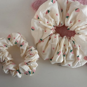 Set of two strawberry pattern scrunchies made of soft cream cotton fabric