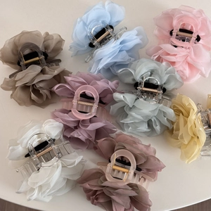 Flat lay of elegant organza rose hair claws in various soft colors for messy bun styles