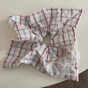 Détail d'un chouchou à carreaux rose et bleu avec bordure en dentelle et petit nœud