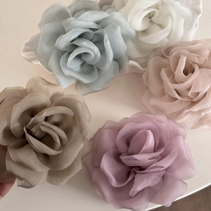 Detail of multi-layered organza rose hair clips in diverse soft colors for elegant styling
