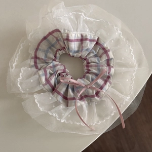 Détail du chouchou à carreaux avec bordure en dentelle blanche et petit nœud rose