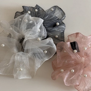 Detailed close-up of glossy organza hair scrunchies with silver silk threads and pearls