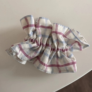 Vue détaillée du chouchou en tissu à carreaux avec motif rose et bleu et bordure bleue