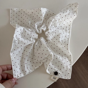 Dettaglio dell'elastico bianco a pois rossi con etichetta fatta a mano e bottone