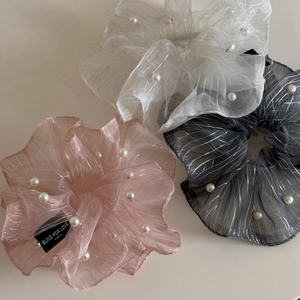 Detail of glitter organza scrunchies with white pearls in pink, white, and black colors