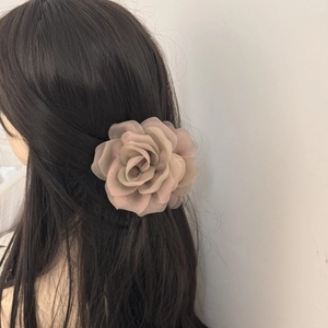 Detail of elegant chiffon rose hair claw clip showing realistic multi-layered fabric petals