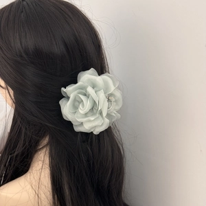 Detail of elegant silver organza rose hair claw clip on dark hair for hair styling