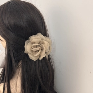 Detail of elegant beige organza rose hair claw showing layered petals and 3D floral texture