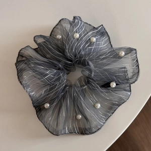 Close-up of grey organza scrunchie with silver stripes and elegant white pearls decoration