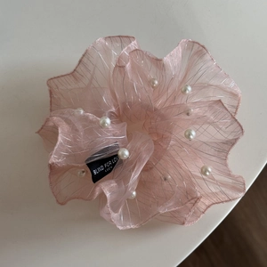 Detail of light pink mesh scrunchie with metallic threads and white faux pearls decor