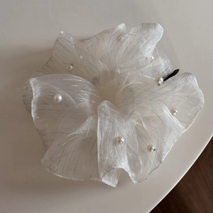 Detailed shot of white organza scrunchie with silver glitter threads and faux pearls