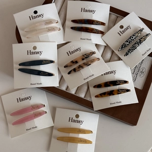 Detail of assorted acetate hair clips with marble patterns on a display tray
