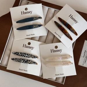 Detailed close-up of acetate bobby pins in multiple colors on branded display cards