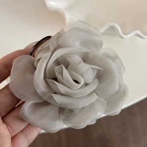 Close-up of layered silver-grey chiffon rose hair claw clip with semi-transparent petals