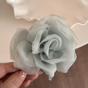 Close-up of a blue tulle rose hair claw showing layered fabric and delicate texture