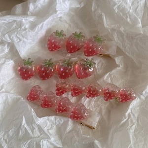 Gedetailleerde weergave van schattige aardbeien haarspelden in hars met roze texturen