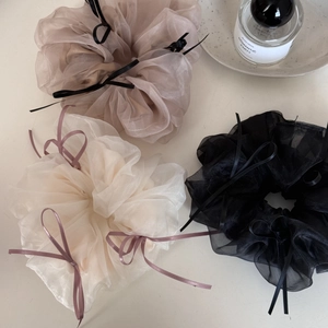 Three elegant tulle scrunchies with ribbon bows in white, champagne, and black colors