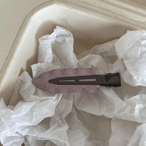 Détail de la pince à cheveux ondulée violette Morandi avec finition mate sur fond blanc