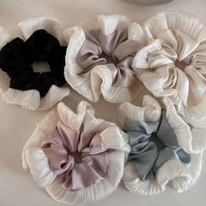 Detailed view of large pleated scrunchies with dual-layered satin fabric in five soft colors