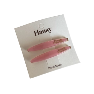 Pink acetate willow-leaf hair clip set with gold lettering on white display card