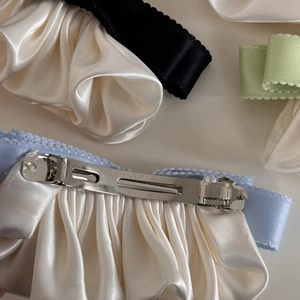 Close-up of the metal spring clip back and satin bow detail with CLIP FRANCE engraving