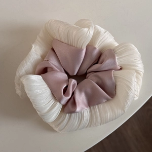 Detailed macro view of pleated oversized scrunchie in beige and mauve satin fabric