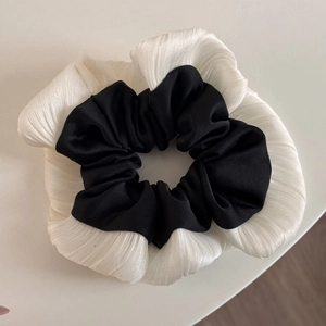 Detailed view of bicolor black satin and white pleated ruffles on the large scrunchie