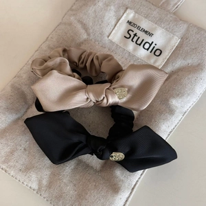 Detail of satin bow hair scrunchies with engraved Made With Love metal charms