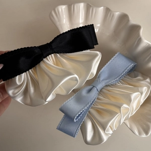 Close-up of French vintage bow hair clips with pleated satin fabric and houndstooth edges
