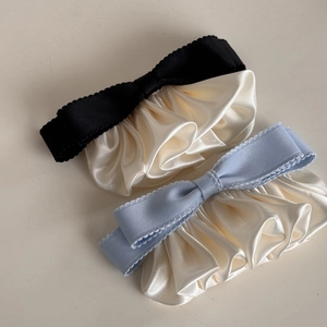 Close-up of elegant pleated satin hair clips with ruffled edges and vintage bow design