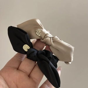 Elegant satin bow hair clips in black and champagne gold with metal love charms