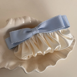 Close-up of French vintage light blue bow hair clip with ivory pleated satin on shell plate
