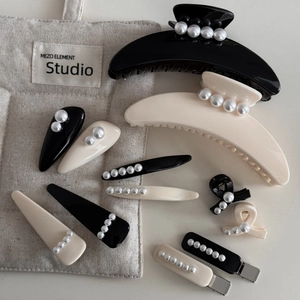 Detalle de pinzas para el cabello estilo francés vintage con perlas blancas y negro