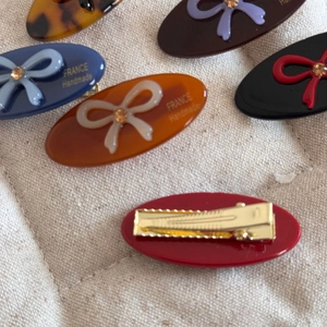 Detail view of colorful resin hair clips with rhinestones and metal duckbill clips