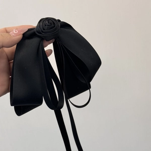 Elegant black satin hair clip with a 3D rose accent and long flowing ribbon streamers