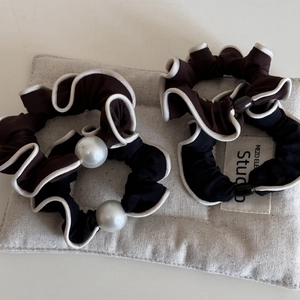 Detail of satin scrunchies with white contrast edges and elegant pearl bead decorations