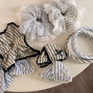 Dettaglio di elastico a righe con cuori rossi e accessori per capelli in pizzo