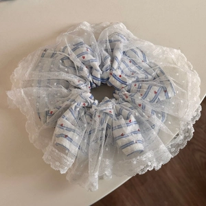 Dettaglio di un elastico in pizzo con strisce blu e piccoli cuori rossi su bianco