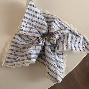 Dettaglio dell'elastico a righe blu con cuori rossi e bordo in pizzo bianco